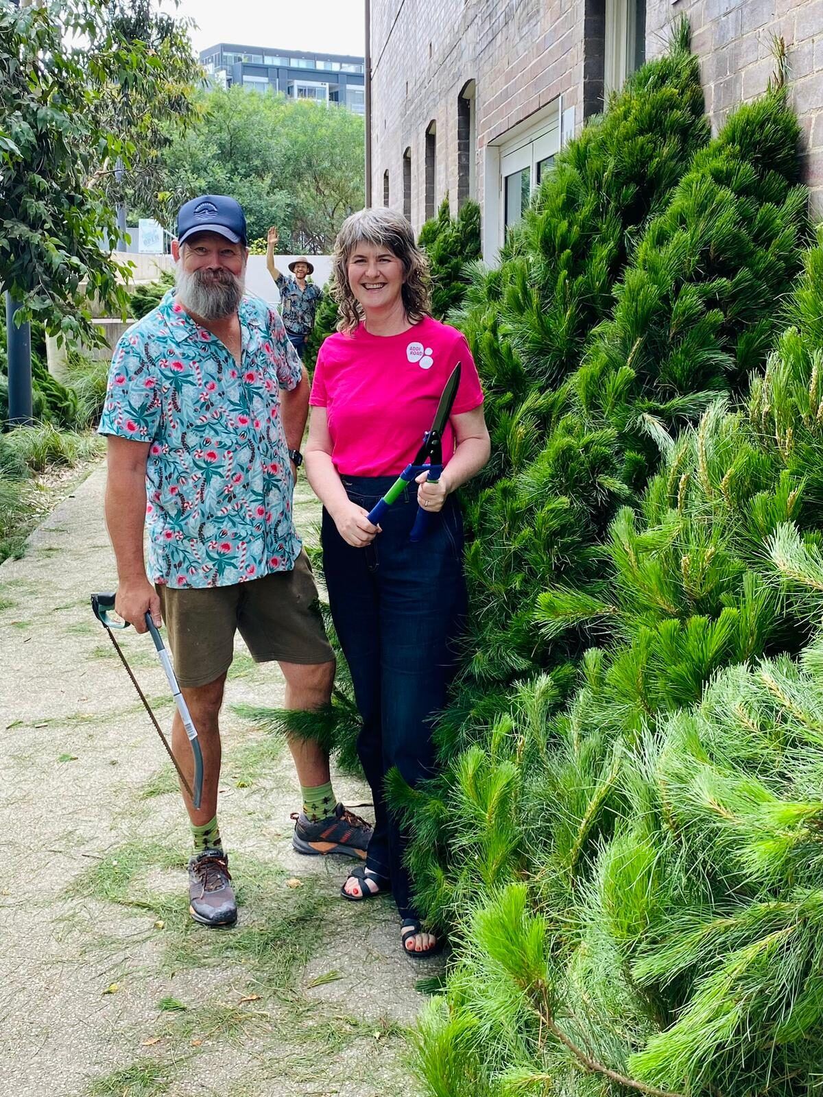 Pick A Tree team member and customer with fresh Christmas trees